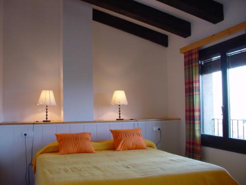 a bedroom with a bed with two lamps on it at Apartamento con chimenea - Golfes Cal Gravat in Montsonis