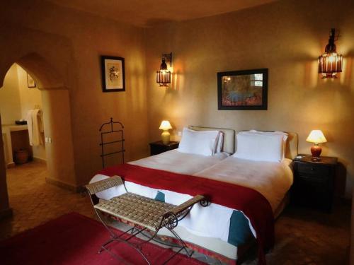 a bedroom with a large bed and a chair at Palais Oumensour in Taroudant