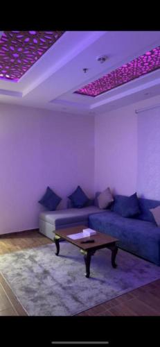 a living room with a blue couch and a coffee table at منتجع شاطي الاحلام in Yanbu