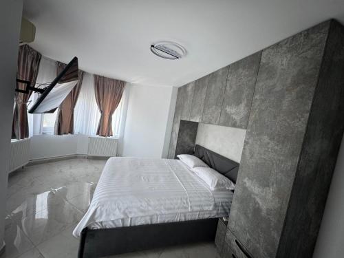 a bedroom with a bed with a concrete wall at Vila Matei in Techirghiol