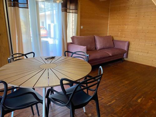 a table and chairs and a couch in a room at Villa Amber in Sarbinowo