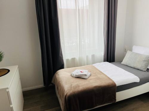 a small bedroom with a bed and a window at Mythos Hotel Oranienburg in Oranienburg