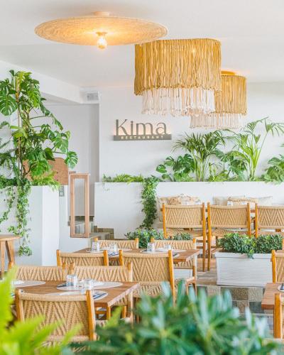 a restaurant with wooden tables and chairs and plants at Artemis in Makry Gialos
