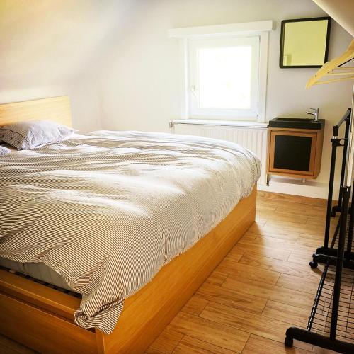 a bed in a bedroom with a window and a television at Maison du golf in Nieuwpoort
