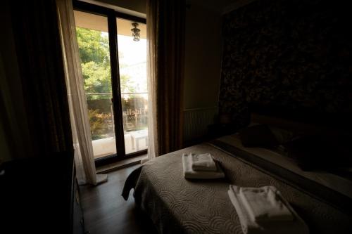 a bedroom with a bed and a large window at Silver Apartments near Airport and Iulius Mall in Iaşi
