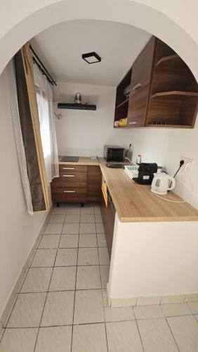 a kitchen with wooden cabinets and a tile floor at Ciao Bambino! in Fonyód