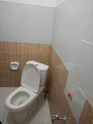 a bathroom with a white toilet in a stall at Cabugao Lodge in El Nido