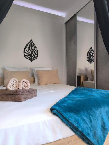 - une chambre avec un grand lit blanc et une couverture bleue dans l'établissement Studio lumineux et spacieux Juan les pins, à Antibes