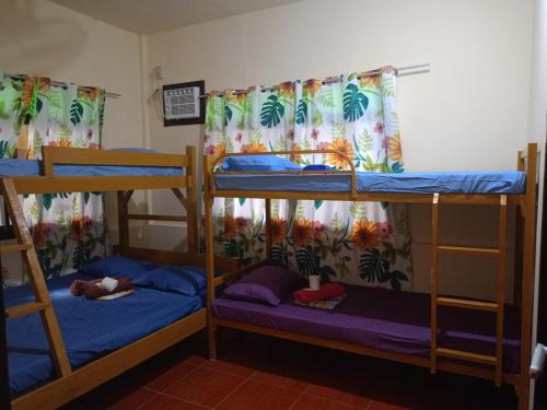 two bunk beds in a room with a person sleeping on them at Cabugao Lodge in El Nido