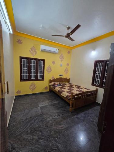 a bedroom with a bed and a ceiling fan at Royal Peters Holiday Homes, Main Falls, Coutralam in Kuttālam