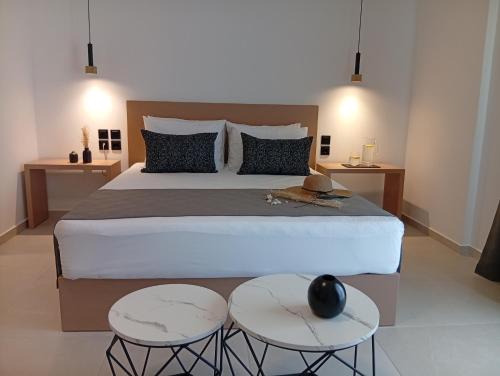 ein Schlafzimmer mit einem großen Bett und zwei Tischen in der Unterkunft Sun Elva in Glífa