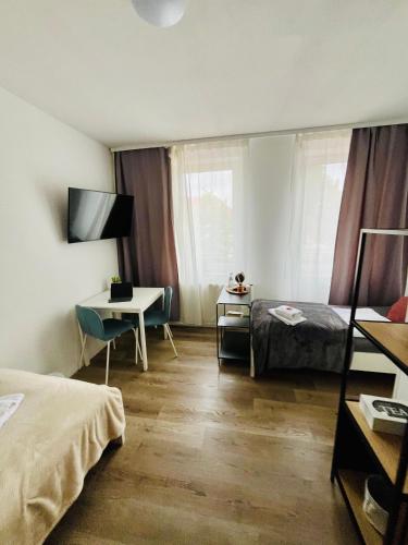 a hotel room with a bed and a desk and a table at Mythos Hotel Oranienburg in Oranienburg