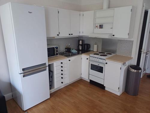 a kitchen with white cabinets and a white refrigerator at Gamla Skolan i Siknäs in Töre