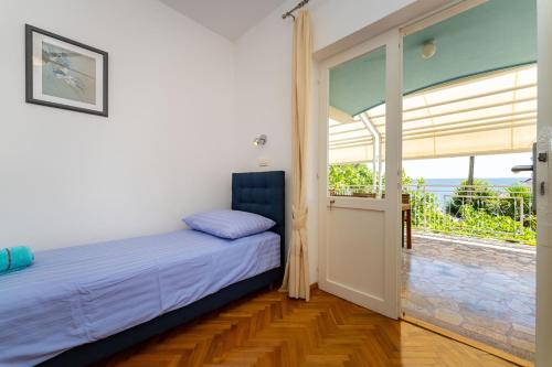 a bedroom with a bed and a large window at MY DALMATIA - Vacation house Maslenica with sea view terrace in Šarić