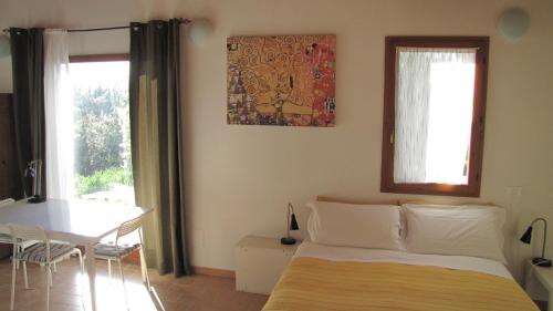 a bedroom with a bed and a table and window at Country House-B&B-Appartamenti Ai Cipressi in Urbino