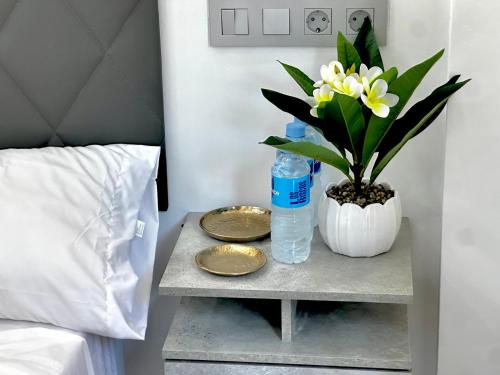 a table with two plates and a bottle of water and a plant at AP Rooms in Almorox