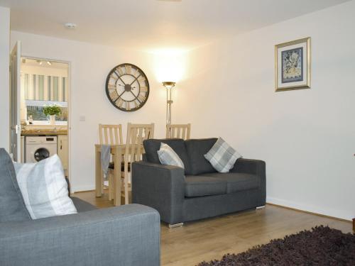 un salon avec un canapé et une horloge au mur dans l'établissement Mountain View, à Blaenau Ffestiniog