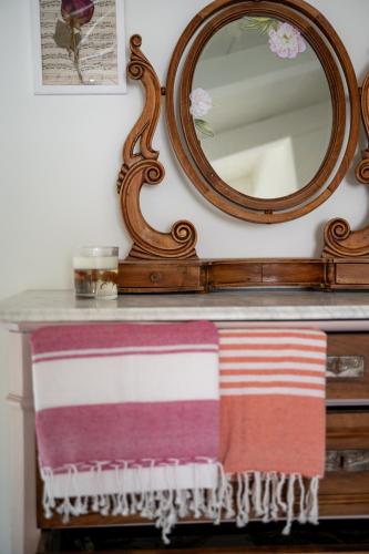 a mirror above a dresser with two towels on it at Casa Viola Bed and Breakfast Dimora di campagna in Calice Ligure