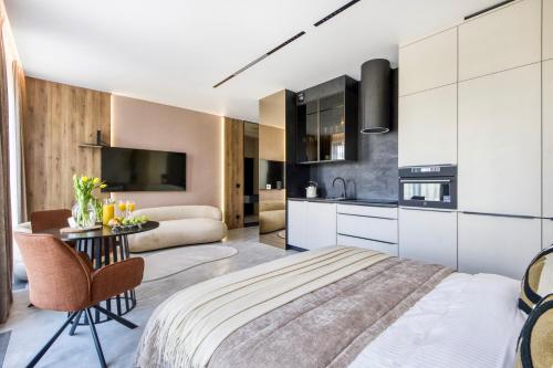 1 dormitorio con 1 cama extragrande y cocina en Chronos Luxury Apartments, en Varsovia