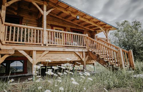 a log cabin with a large wooden deck at Gîte de l'herboriste in Sainte-Rose-du-Nord