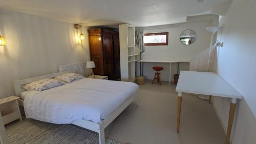 une chambre avec un lit blanc et une table dans l'établissement Le petit FrEd, à Seebach