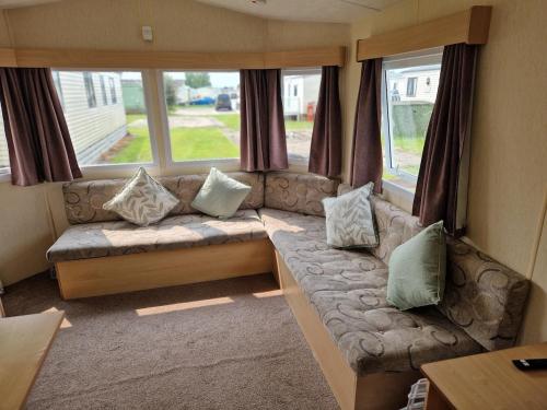 a living room with a couch with pillows at The Cosy Coastal Caravan in Morecambe