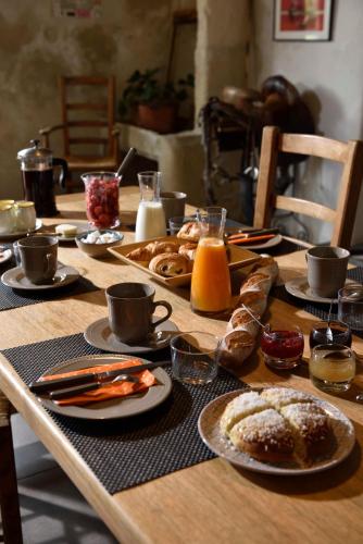 un tavolo in legno ricoperto di piatti di cibo e caffè di Mas de Bouvet en Camargue ad Albaron