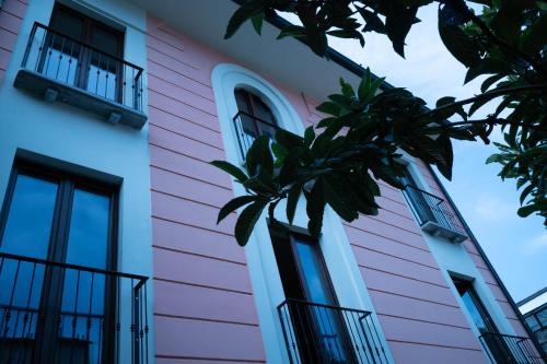 a pink building with a palm tree in front of it at MIA HOME experience in Milan