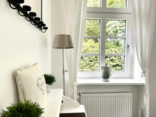 a white room with a window and a chair at Romantikhaus am Hafen in Greetsiel in Greetsiel