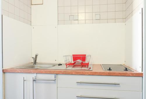 une cuisine avec un évier et un panier rouge sur le comptoir dans l'établissement Mezzanino by POM, pkg, mezzanine, au Cap d'Agde