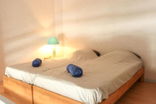 un lit avec deux oreillers bleus dessus dans l'établissement Mezzanino by POM, pkg, mezzanine, au Cap d'Agde