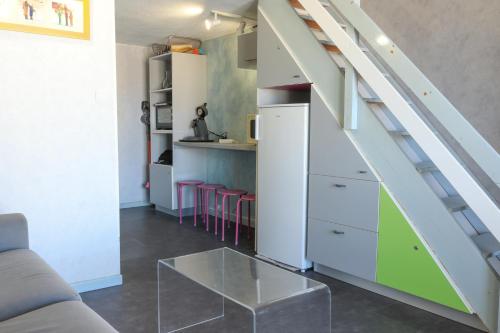 un salon avec un escalier et une cuisine avec des tabourets dans l'établissement Mezzanino by POM, pkg, mezzanine, au Cap d'Agde