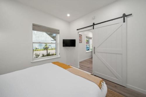 a bedroom with a large white bed with a sliding barn door at Pismo Beach Club in Pismo Beach
