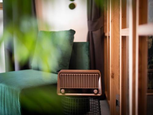 a room with a green bed with a radiator at Goldengel Design - Suiten im historischen Ortskern von Kaltern in Caldaro