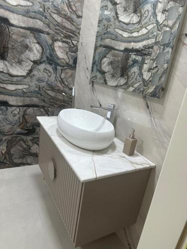 a bathroom with a sink and a mirror at Garden Homes 3 in Mekhrably