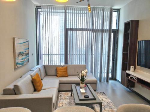 a living room with a couch and a table at Brand New Luxury One Bedroom in Dubai