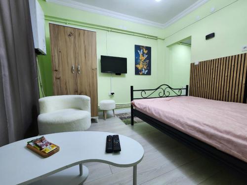 a bedroom with a bed and a table and a tv at Q Apart in Eskisehir