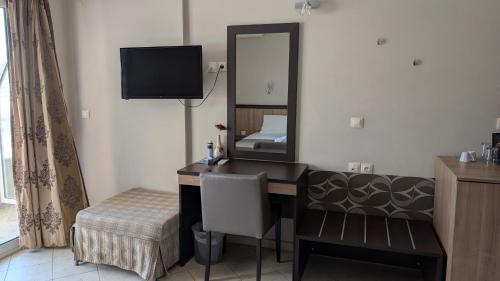 a room with a desk with a mirror and a bed at Sarti Plaza in Sarti