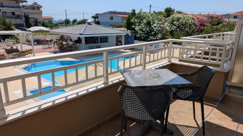 a balcony with a table and chairs and a pool at Sarti Plaza in Sarti