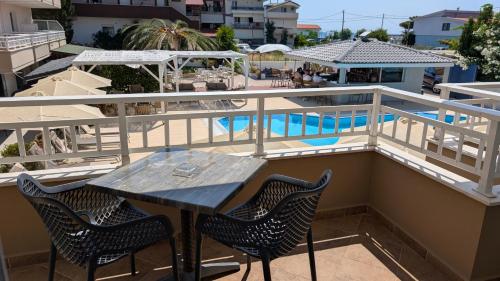 a table and chairs on a balcony with a pool at Sarti Plaza in Sarti