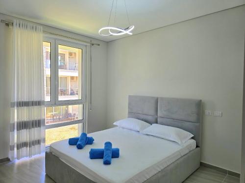 a bedroom with a bed with two blue pillows on it at Holiday Apartment in San Pietro Residence 304 in Lalzit Bay