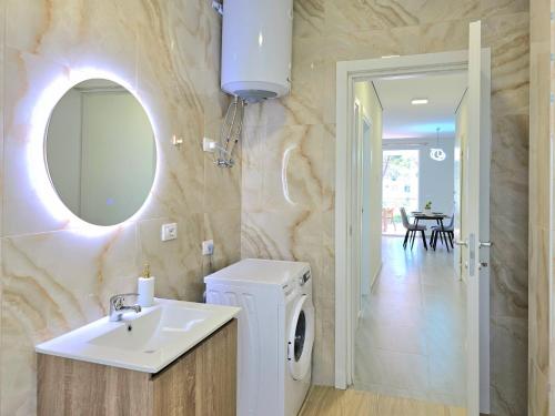 a bathroom with a sink and a washing machine at Holiday Apartment in San Pietro Residence 304 in Lalzit Bay