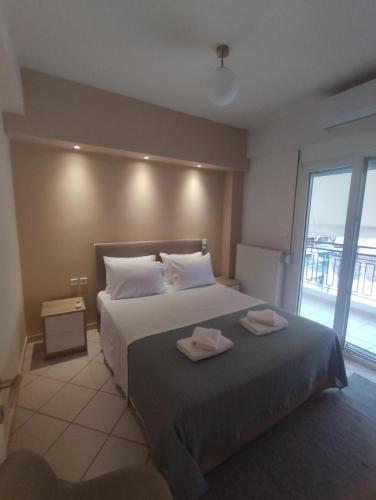 ein Schlafzimmer mit einem Bett, auf dem zwei Handtücher liegen in der Unterkunft ZenPoint in Larisa