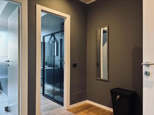 a bathroom with a glass shower and a mirror at Monza Park Comfort Apartment in Monza