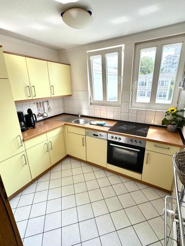 a kitchen with yellow cabinets and a stove at Meerblick Apartment in Göhren