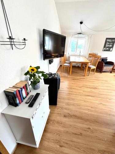 a living room with a television on a wall at Meerblick Apartment in Göhren