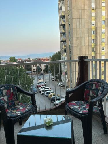 a balcony with chairs and a table and a view of a parking lot at Meri Apartment in Bitola