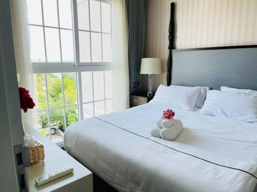 - un ours en peluche assis sur un lit dans une chambre d'hôtel dans l'établissement Grand Florida Beachfront Pattaya, à Na Jomtien