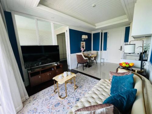 un salon avec un canapé et une télévision dans l'établissement Grand Florida Beachfront Pattaya, à Na Jomtien