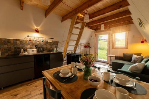 a kitchen and living room with a table in a room at Siódme Niebo domek w górach in Duszniki Zdrój